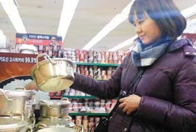 ▲15日午後、大型スーパー「ロッテマート」ソウル駅店でアルマイト鍋を選ぶ中国人客。／写真提供＝ロッテマート