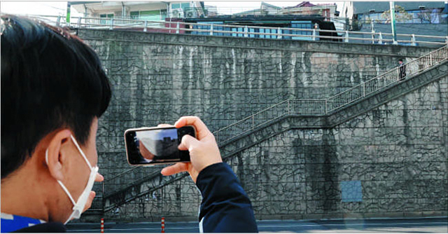 紫霞門トンネル近くの階段をスマートフォンで撮影する観光客。 
