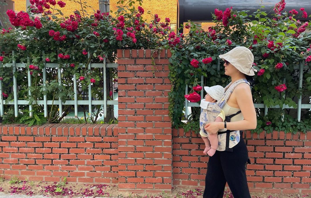 ユン・ジンソ、生後5カ月の娘の姿公開…抱っこひもを利用して花咲く道を散歩