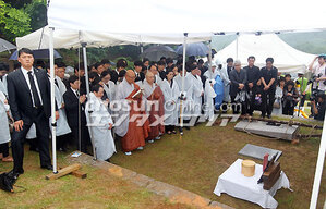 【フォト】雨中の納骨式、優しい笑顔の遺影