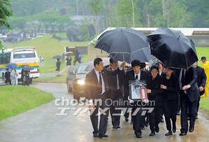 【フォト】雨中の納骨式、優しい笑顔の遺影